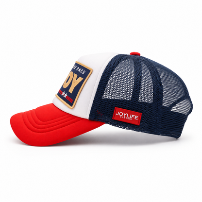 Side view of trucker cap with navy mesh back and red side label
