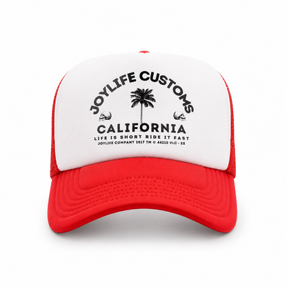 Angled view of white trucker cap with red visor and mesh panels
